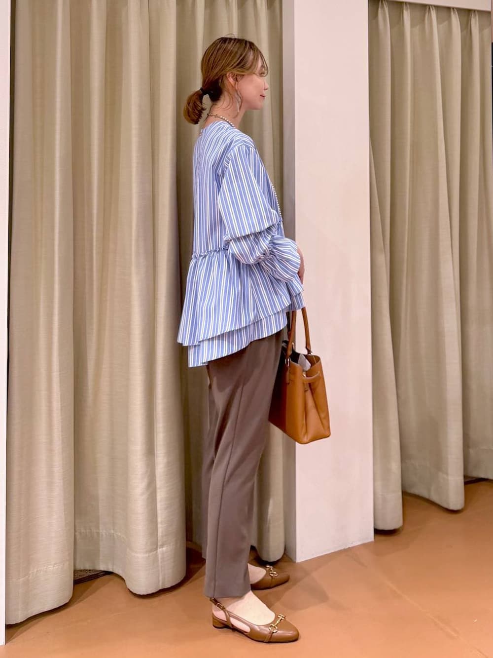 ブラウン系のその他パンツ、イエロー系のハンドバッグ、ブラウン系のパンプスを着用したレディースの春コーディネートの3枚目の写真