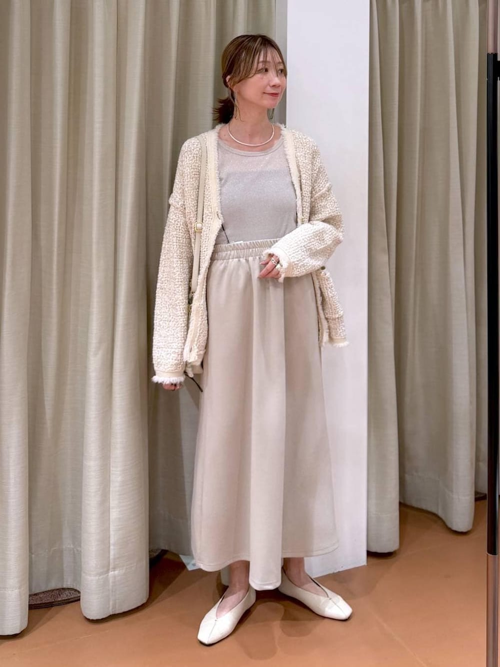 グレー系のTシャツ/カットソー、ホワイト系のハンドバッグ、ホワイト系のパンプスを着用したレディースの春コーディネートの2枚目の写真