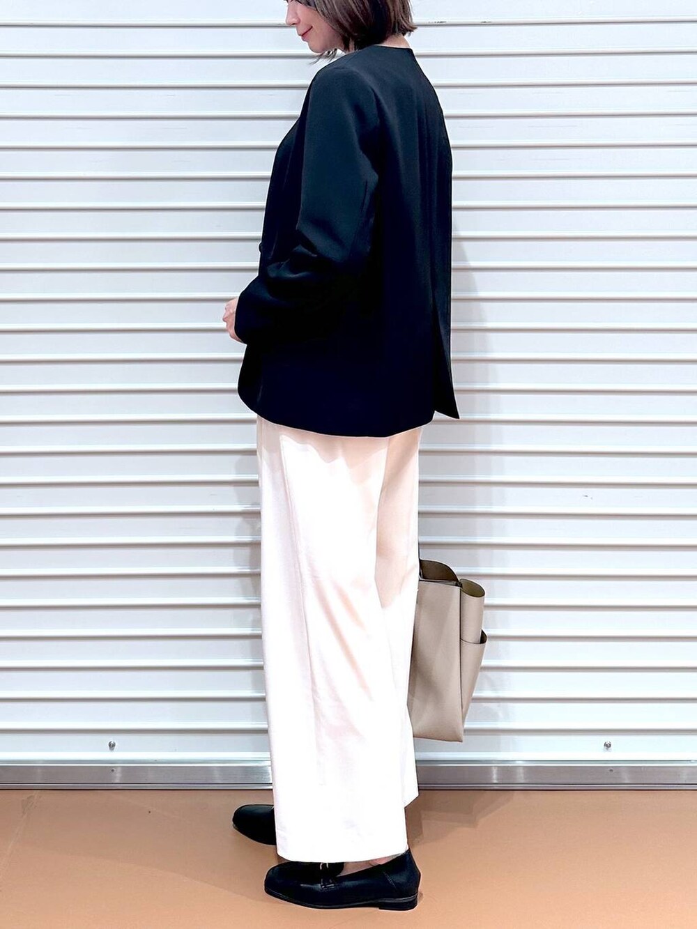 ブラック系のシャツ/ブラウス、ホワイト系のその他パンツ、ベージュ系のトートバッグを着用したレディースの春コーディネートの9枚目の写真