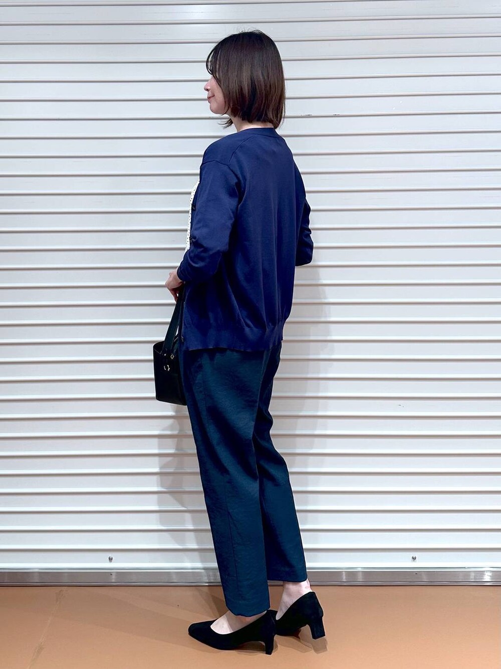 ホワイト系のシャツ/ブラウス、ブルー系のカーディガン/ボレロ、ブラック系のハンドバッグを着用したレディースの夏コーディネートの6枚目の写真