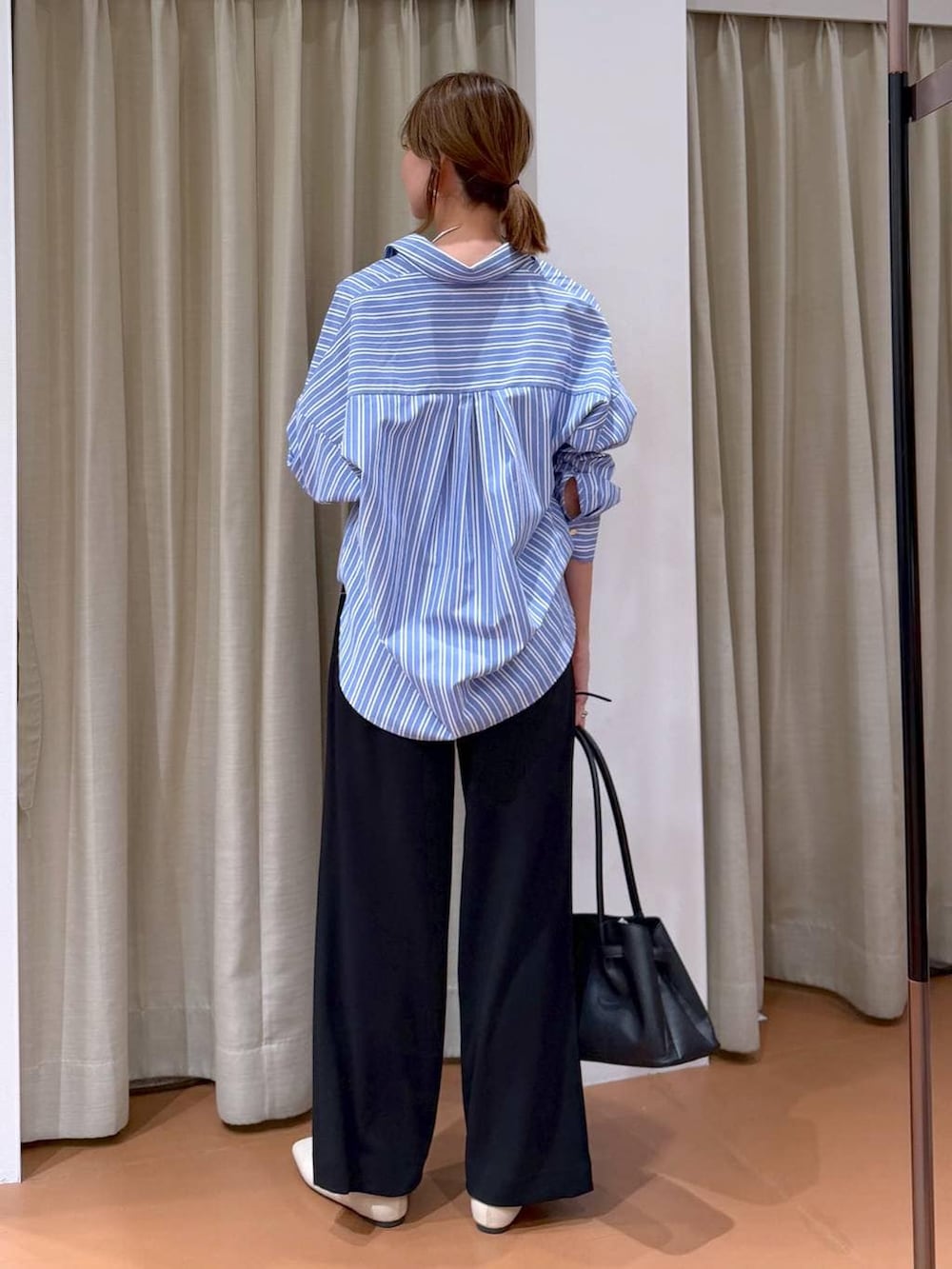 ブラック系のその他パンツ、ホワイト系のパンプス、ブラック系のハンドバッグを着用したレディースの冬コーディネートの4枚目の写真