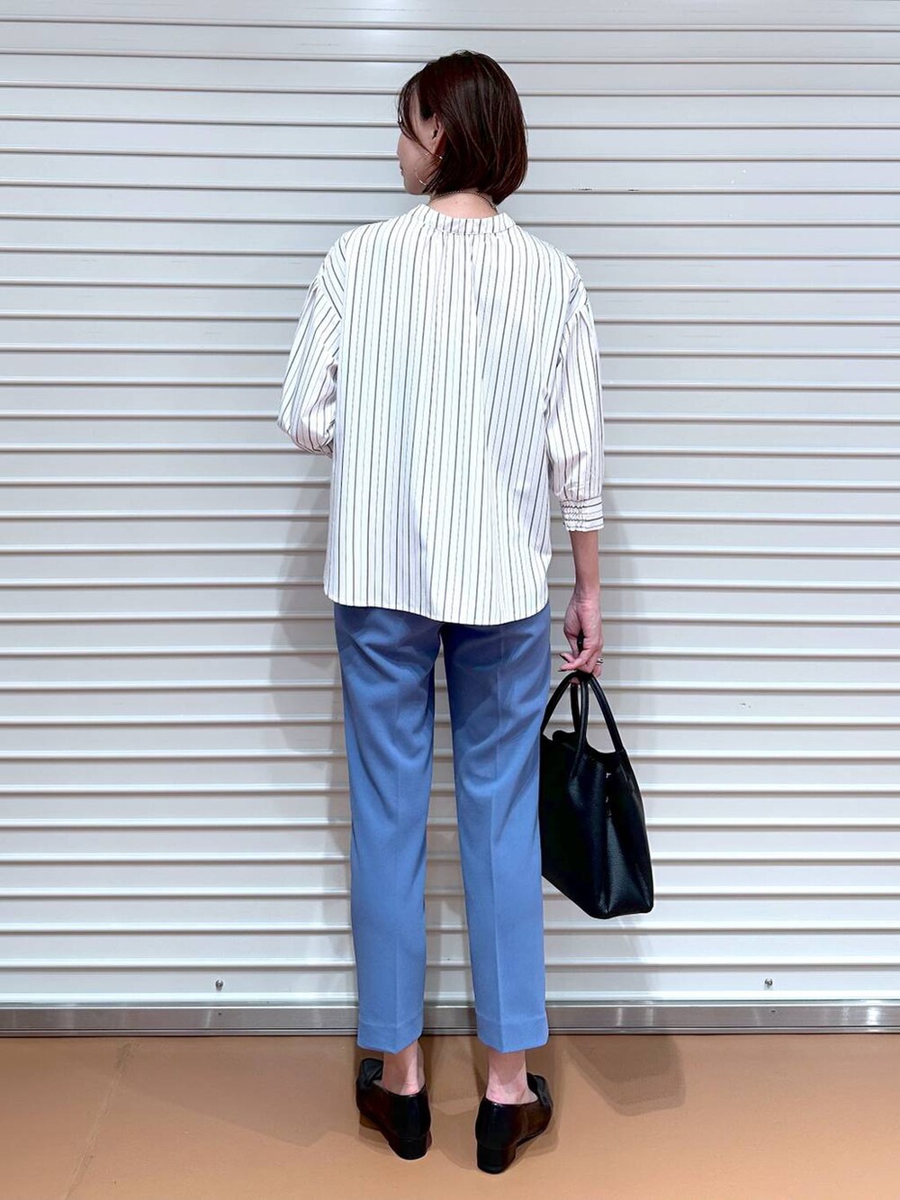 ブルー系のその他パンツ、ブラック系のハンドバッグ、ブラック系のローファーを着用したレディースの秋コーディネートの4枚目の写真