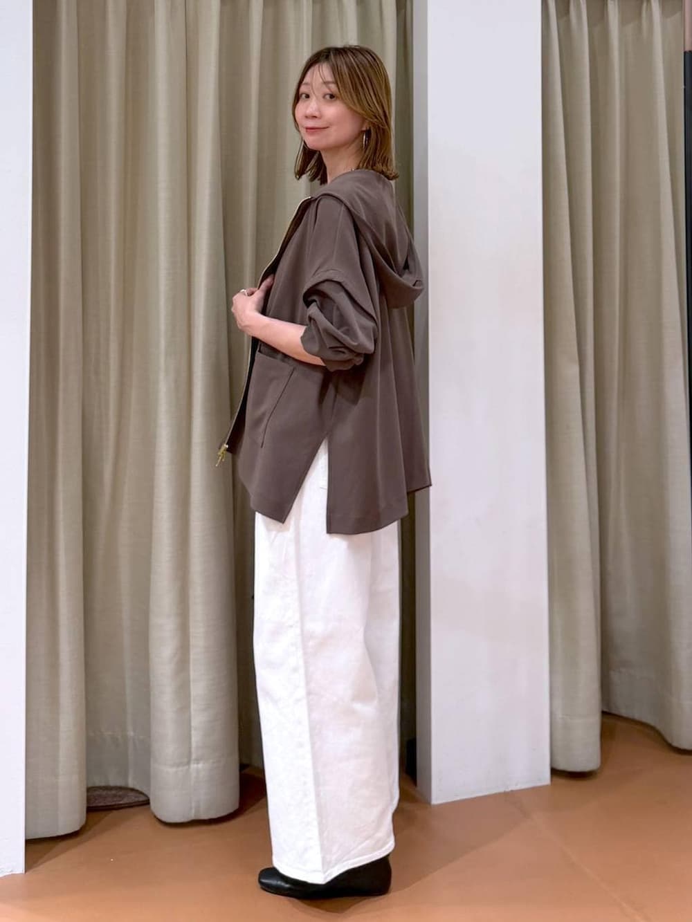 ブラック系のパンプス、ホワイト系のデニムパンツ、ブラウン系のTシャツ/カットソーを着用したレディースの春コーディネートの3枚目の写真