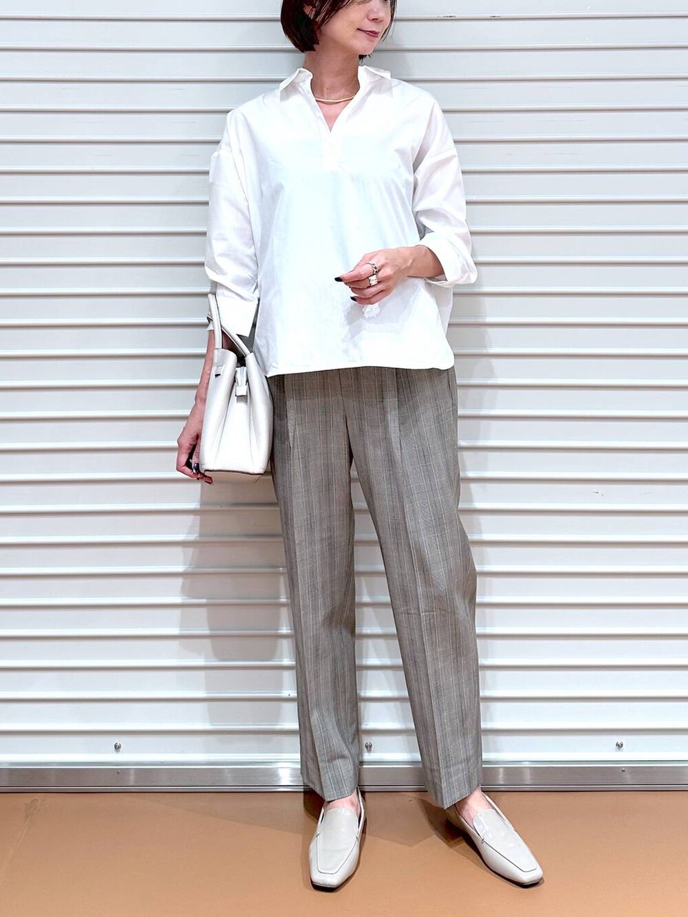ブラウン系のその他パンツ、グレー系のハンドバッグ、ホワイト系のシャツ/ブラウスを着用したレディースの秋コーディネートの5枚目の写真