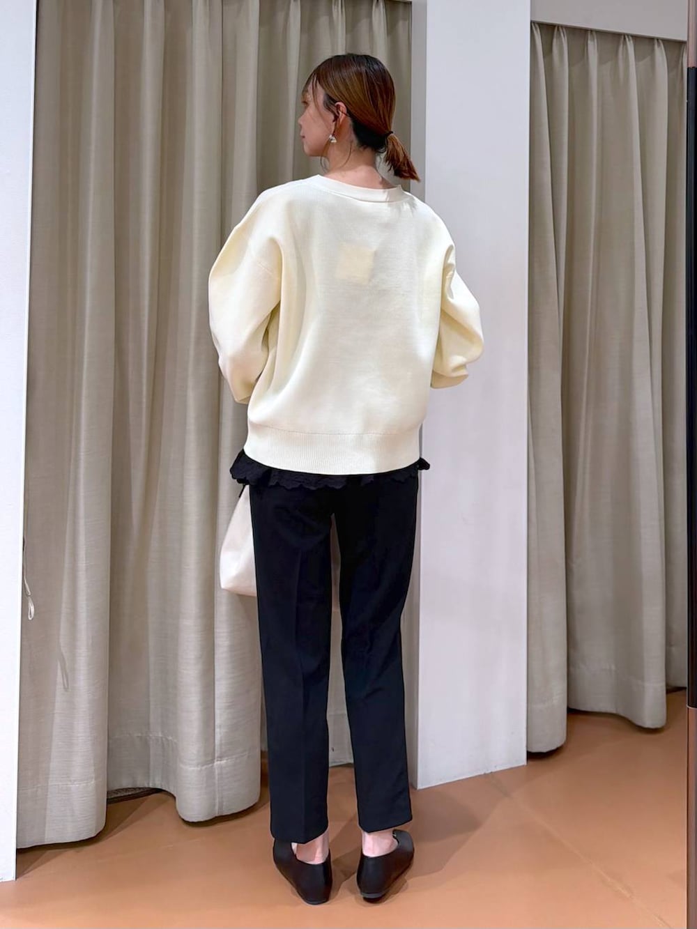 ブラック系のその他パンツ、ブラック系のパンプス、ホワイト系のトートバッグを着用したレディースの冬コーディネートの4枚目の写真