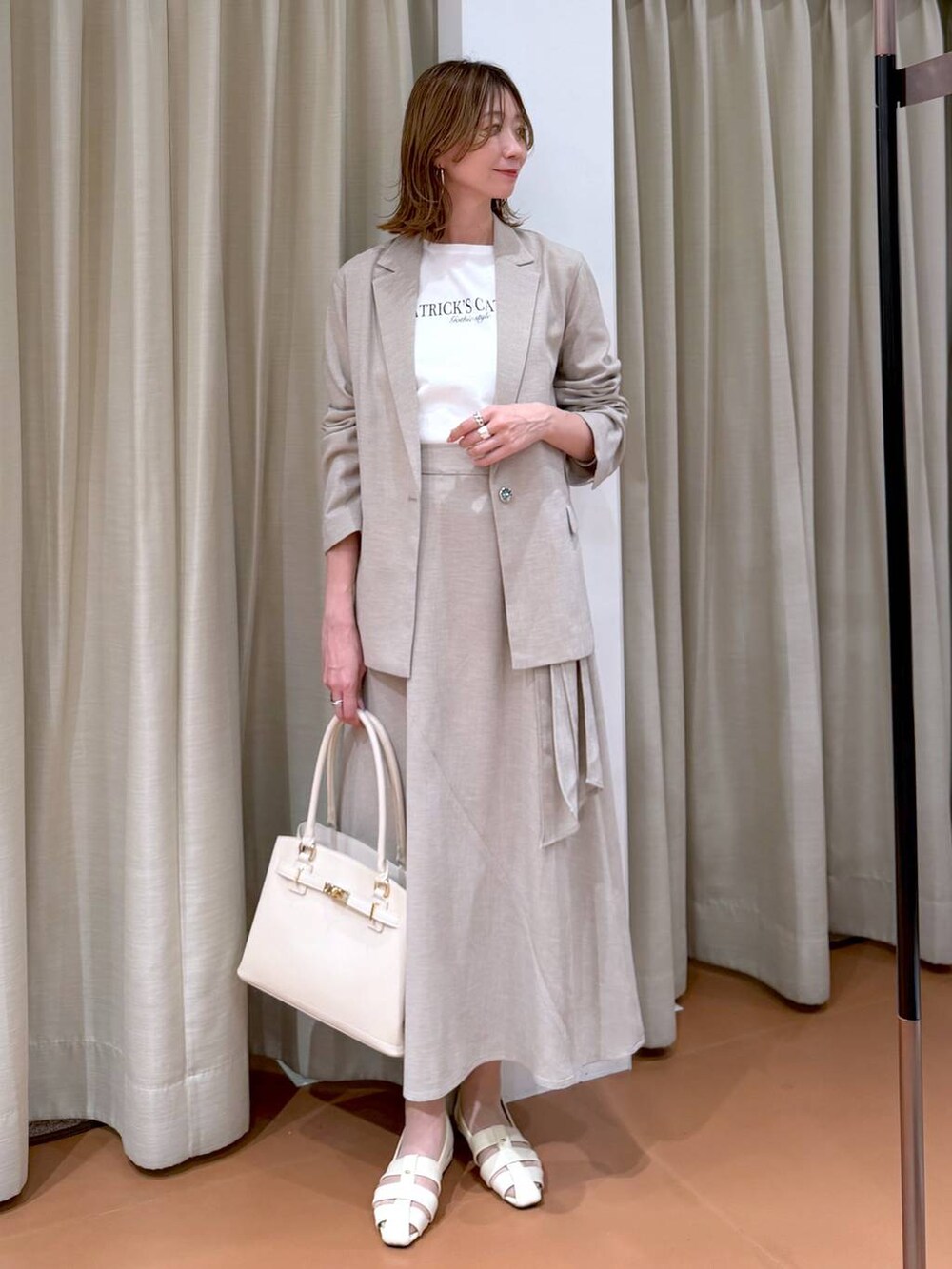 ホワイト系のハンドバッグ、ホワイト系のパンプス、ホワイト系のTシャツ/カットソーを着用したレディースの春コーディネートの6枚目の写真