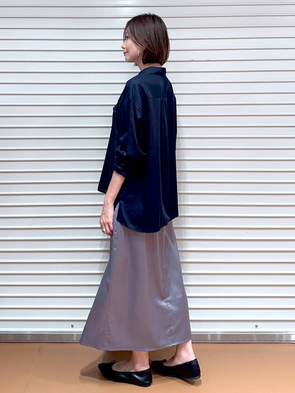 ブルー系のシャツ/ブラウス、ブラック系のパンプス、ブラック系のハンドバッグを着用したレディースの秋コーディネートの3枚目の写真