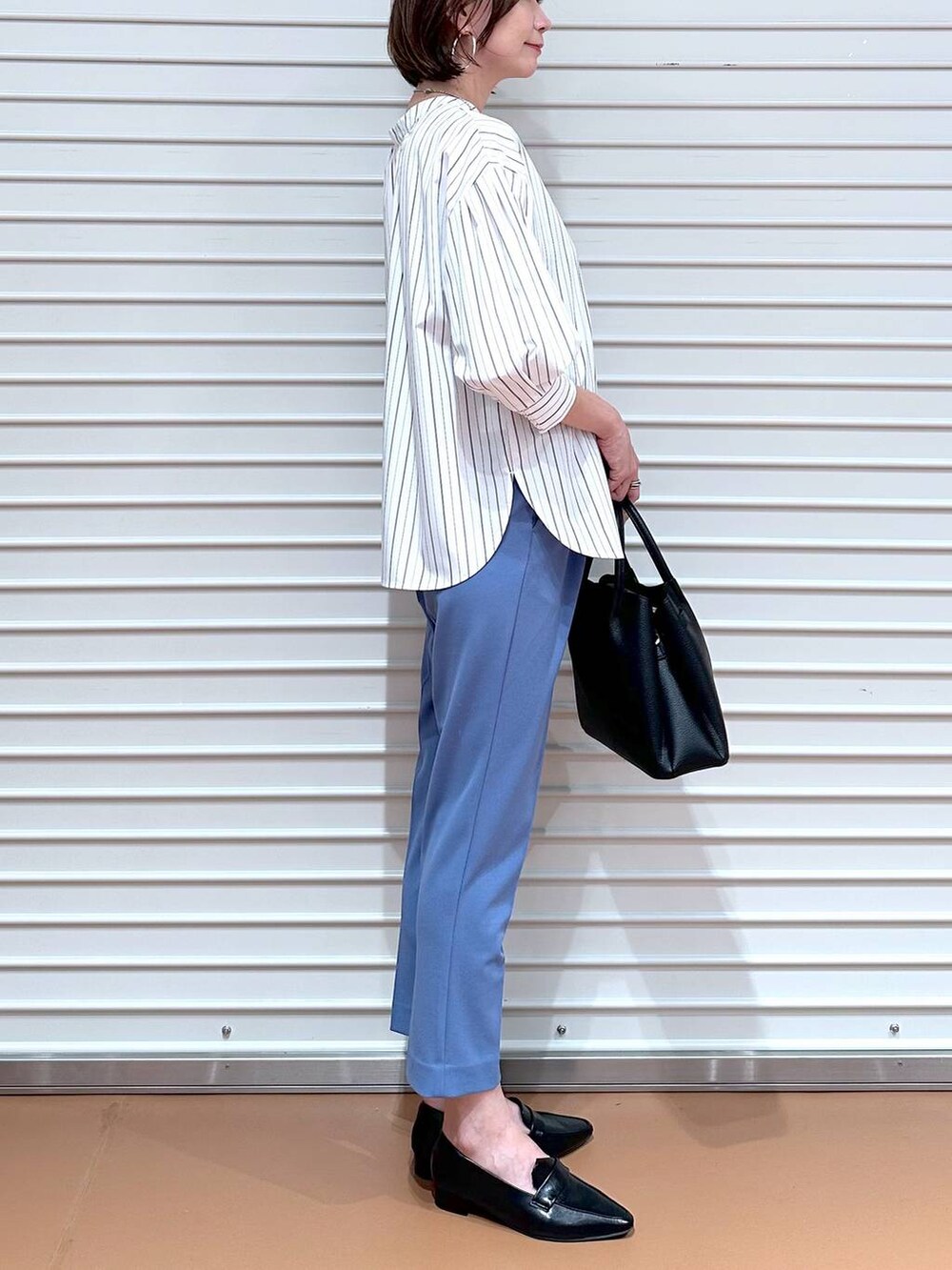 ブルー系のその他パンツ、ブラック系のハンドバッグ、ブラック系のローファーを着用したレディースの秋コーディネートの6枚目の写真