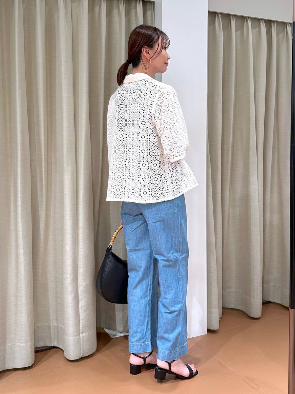 ブラック系のニット/セーター、ブルー系のデニムパンツ、ホワイト系のその他アウターを着用したレディースの夏コーディネートの5枚目の写真