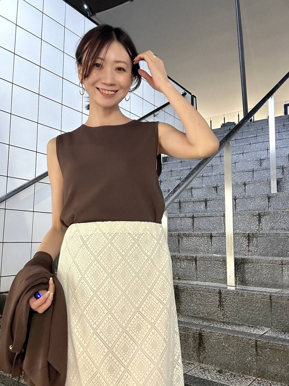 ブラウン系のカーディガン/ボレロ、ブラウン系のニット/セーター、ホワイト系のパンプスを着用したレディースの春コーディネートの5枚目の写真