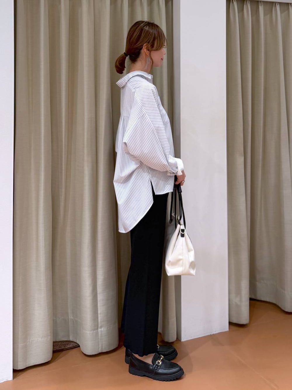 ブラック系のローファー、ホワイト系のトートバッグ、ホワイト系のシャツ/ブラウスを着用したレディースの春コーディネートの5枚目の写真
