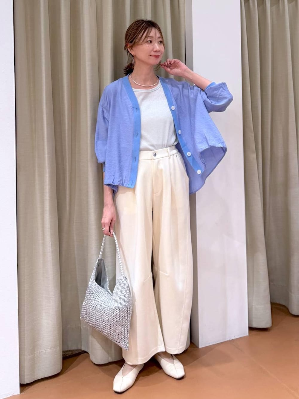ホワイト系のTシャツ/カットソー、ホワイト系のパンプス、ブルー系のカーディガン/ボレロを着用したレディースの春コーディネートの2枚目の写真