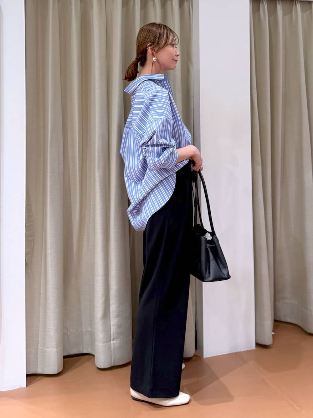 ブラック系のその他パンツ、ホワイト系のパンプス、ブラック系のハンドバッグを着用したレディースの冬コーディネートの5枚目の写真