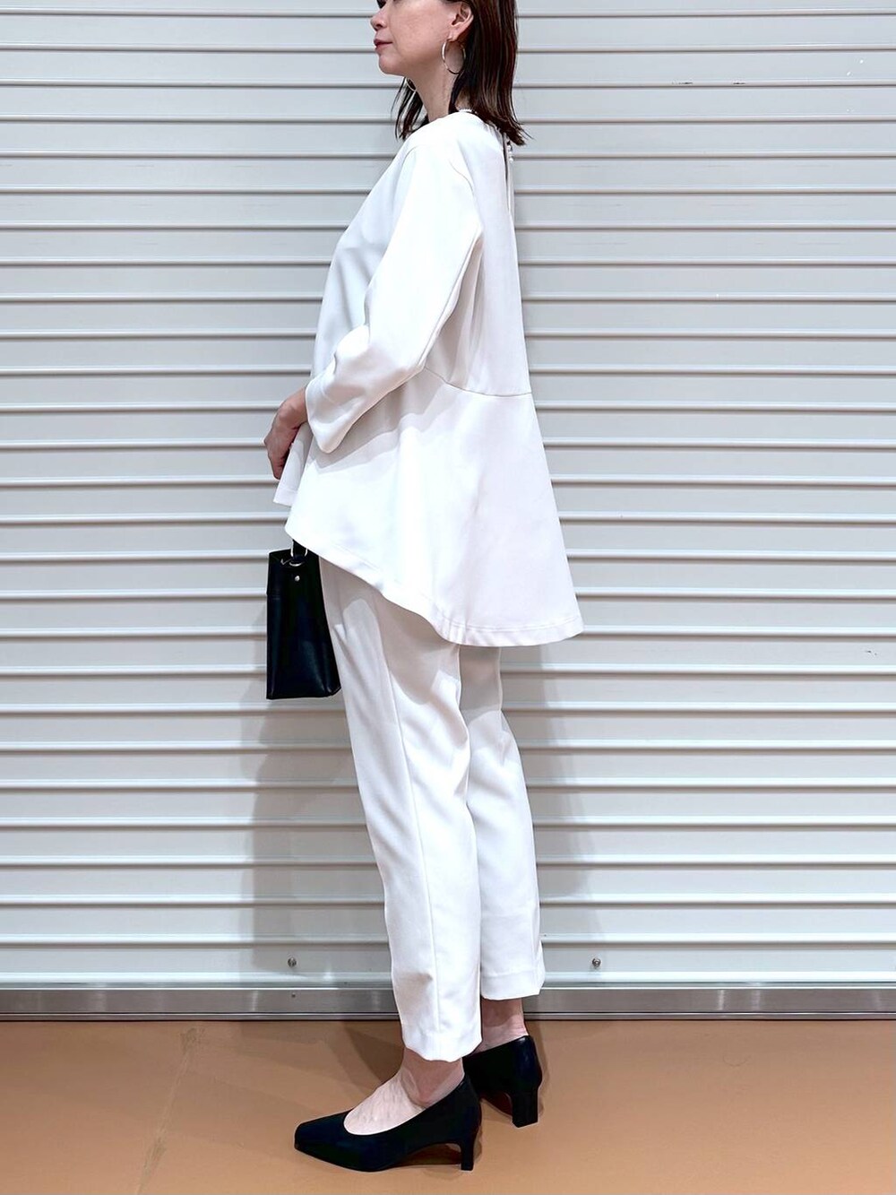 ベージュ系のその他パンツ、ベージュ系のシャツ/ブラウス、ブラック系のハンドバッグを着用したレディースの冬コーディネートの6枚目の写真