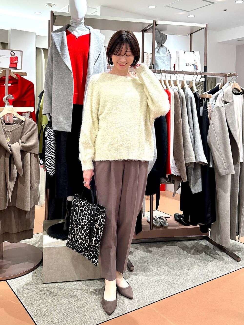 ブラウン系のその他パンツ、ブラウン系のパンプス、ホワイト系のニット/セーターを着用したレディースの冬コーディネートの2枚目の写真