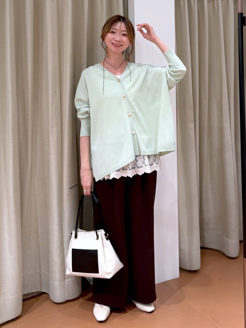 ホワイト系のパンプス、ホワイト系のタンクトップ、ホワイト系のトートバッグを着用したレディースの春コーディネートの2枚目の写真