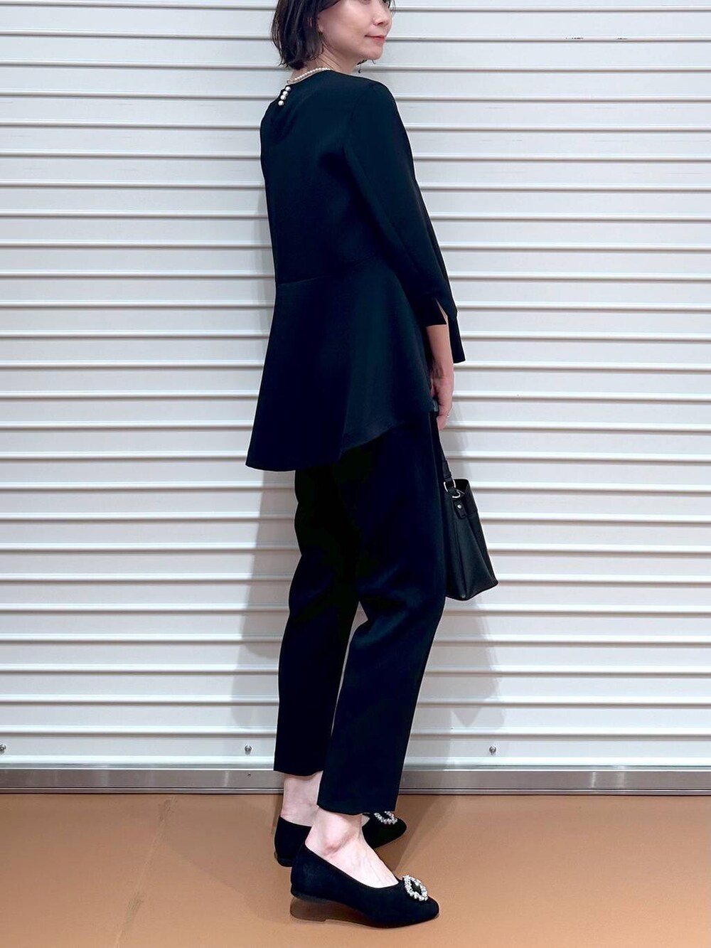 ブラック系のその他パンツ、ブラック系のシャツ/ブラウス、ブラック系のハンドバッグを着用したレディースの春コーディネートの6枚目の写真