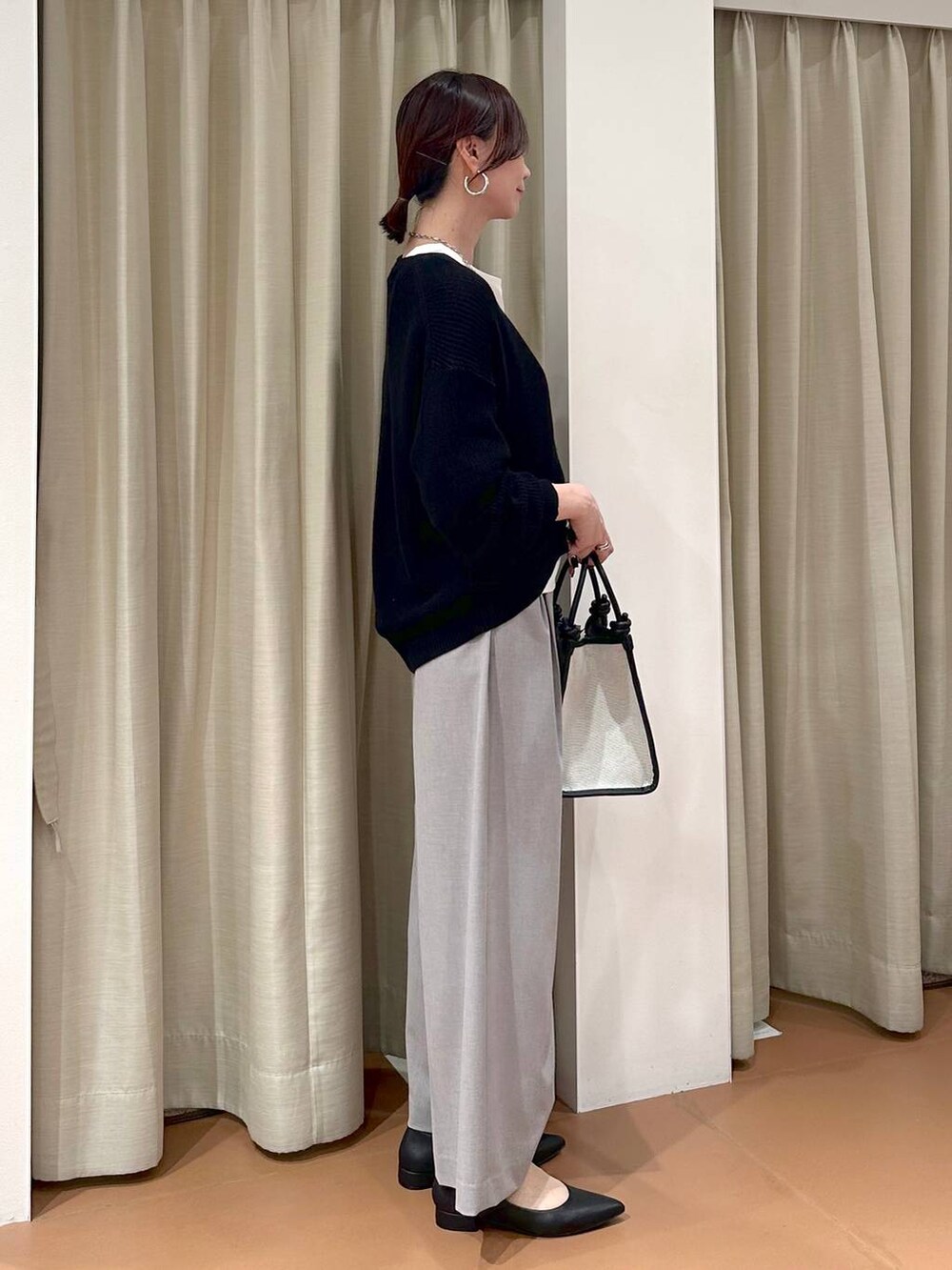 ホワイト系のTシャツ/カットソー、グレー系のその他パンツ、ブラック系のカーディガン/ボレロを着用したレディースの春コーディネートの5枚目の写真