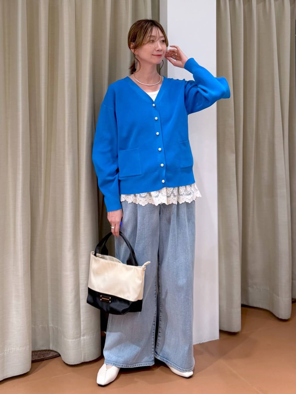 ホワイト系のパンプス、ホワイト系のタンクトップ、ブルー系のデニムパンツを着用したレディースの春コーディネートの2枚目の写真