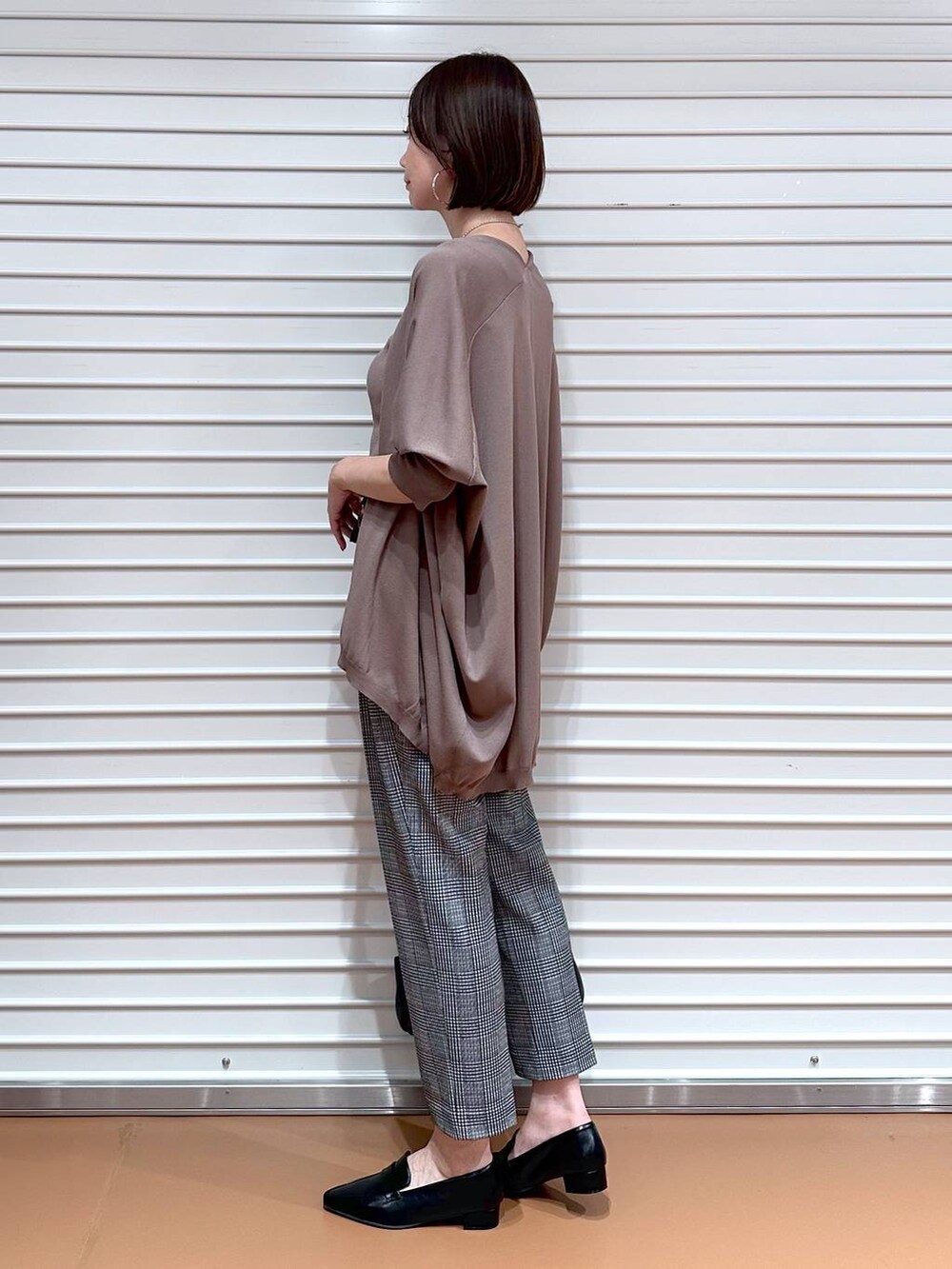 ブラウン系のカーディガン/ボレロ、ブラック系のその他パンツ、ブラウン系のタンクトップを着用したレディースの秋コーディネートの3枚目の写真