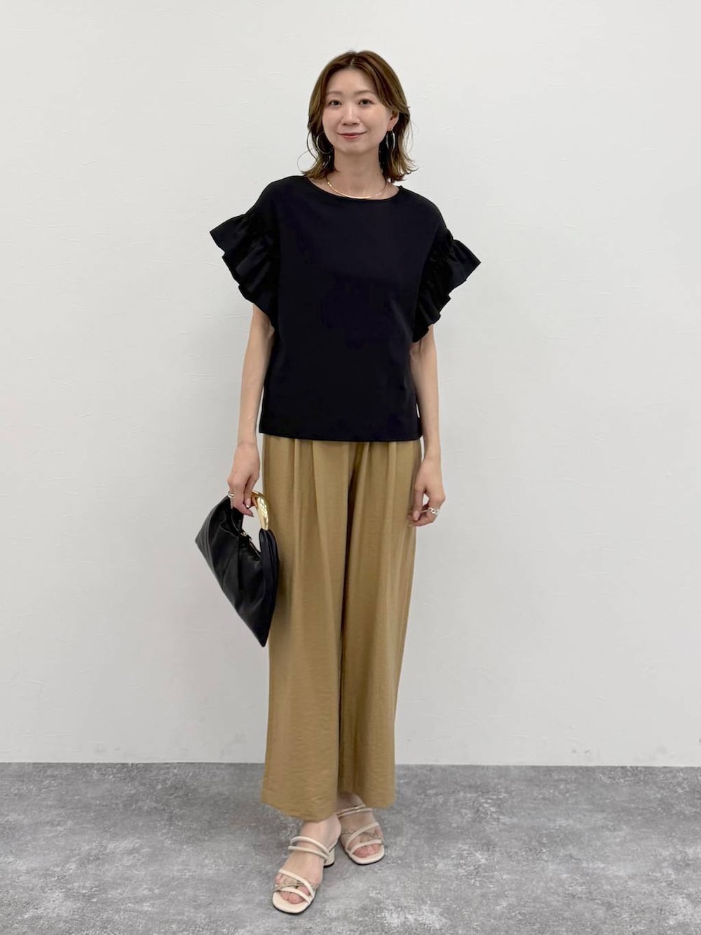 ベージュ系のその他パンツ、ゴールド系のネックレスを着用したレディースの春コーディネートの2枚目の写真