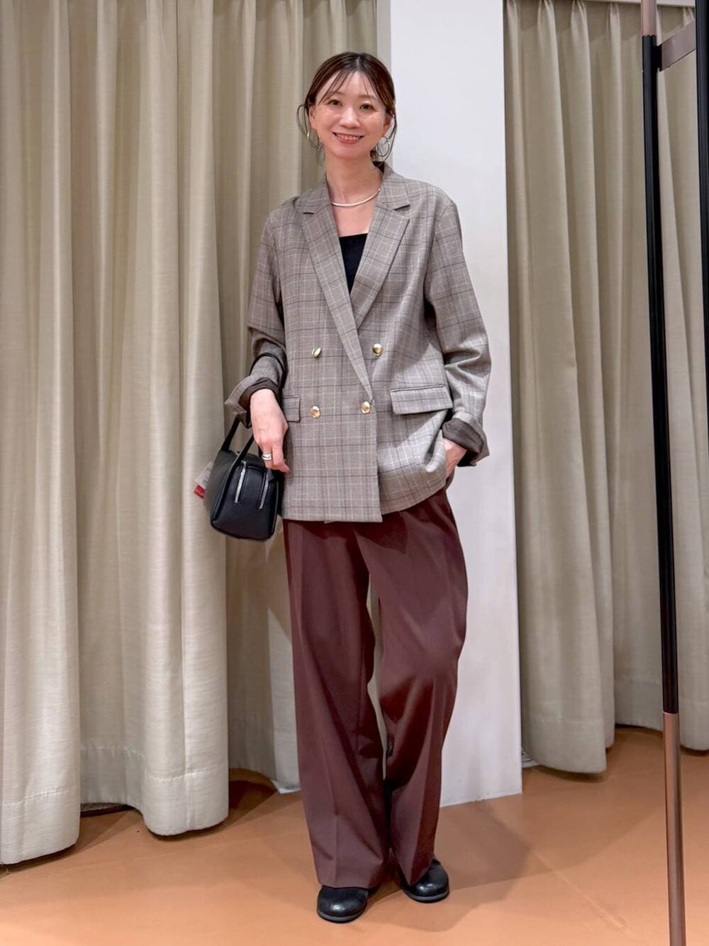 ブラック系のブーツ、ブラック系のテーラードジャケット、ブラック系のショルダーバッグを着用したレディースの冬コーディネートの6枚目の写真