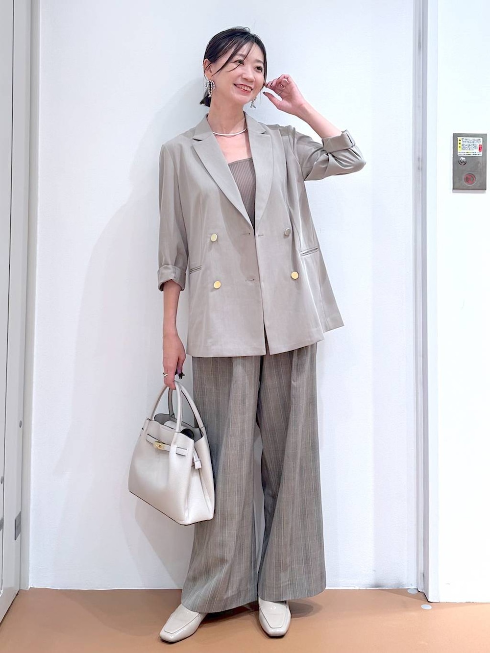 ブラウン系のその他パンツ、グレー系のハンドバッグ、ブラウン系のタンクトップを着用したレディースの秋コーディネートの2枚目の写真