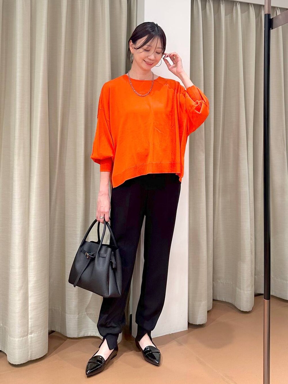 ブラック系のハンドバッグ、ブラック系のパンプス、ブラック系のその他パンツを着用したレディースの春コーディネートの2枚目の写真