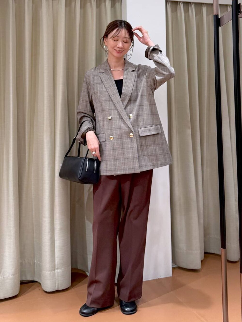 ブラック系のブーツ、ブラック系のテーラードジャケット、ブラック系のショルダーバッグを着用したレディースの冬コーディネートの2枚目の写真