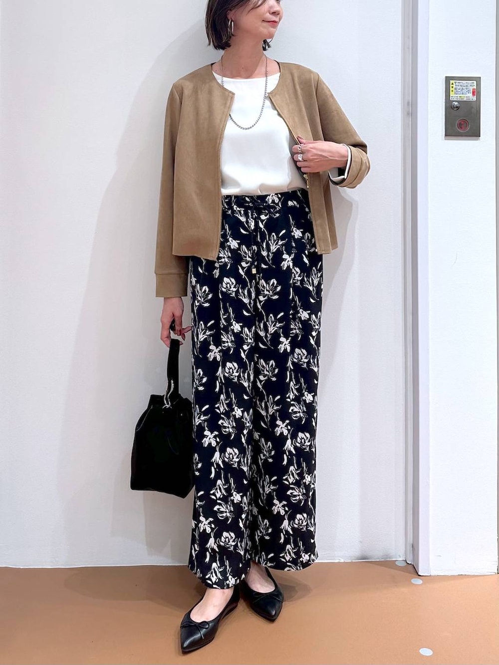 ブラック系のパンプス、ブルー系のその他パンツ、ホワイト系のTシャツ/カットソーを着用したレディースの秋コーディネートの5枚目の写真