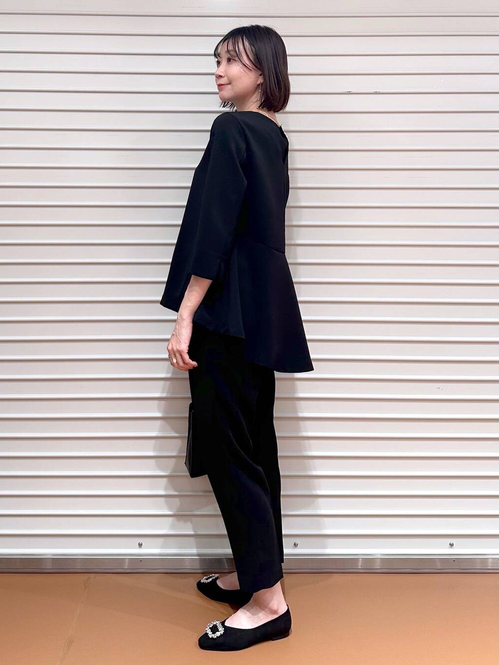 ブラック系のその他パンツ、ブラック系のシャツ/ブラウス、ブラック系のハンドバッグを着用したレディースの春コーディネートの3枚目の写真