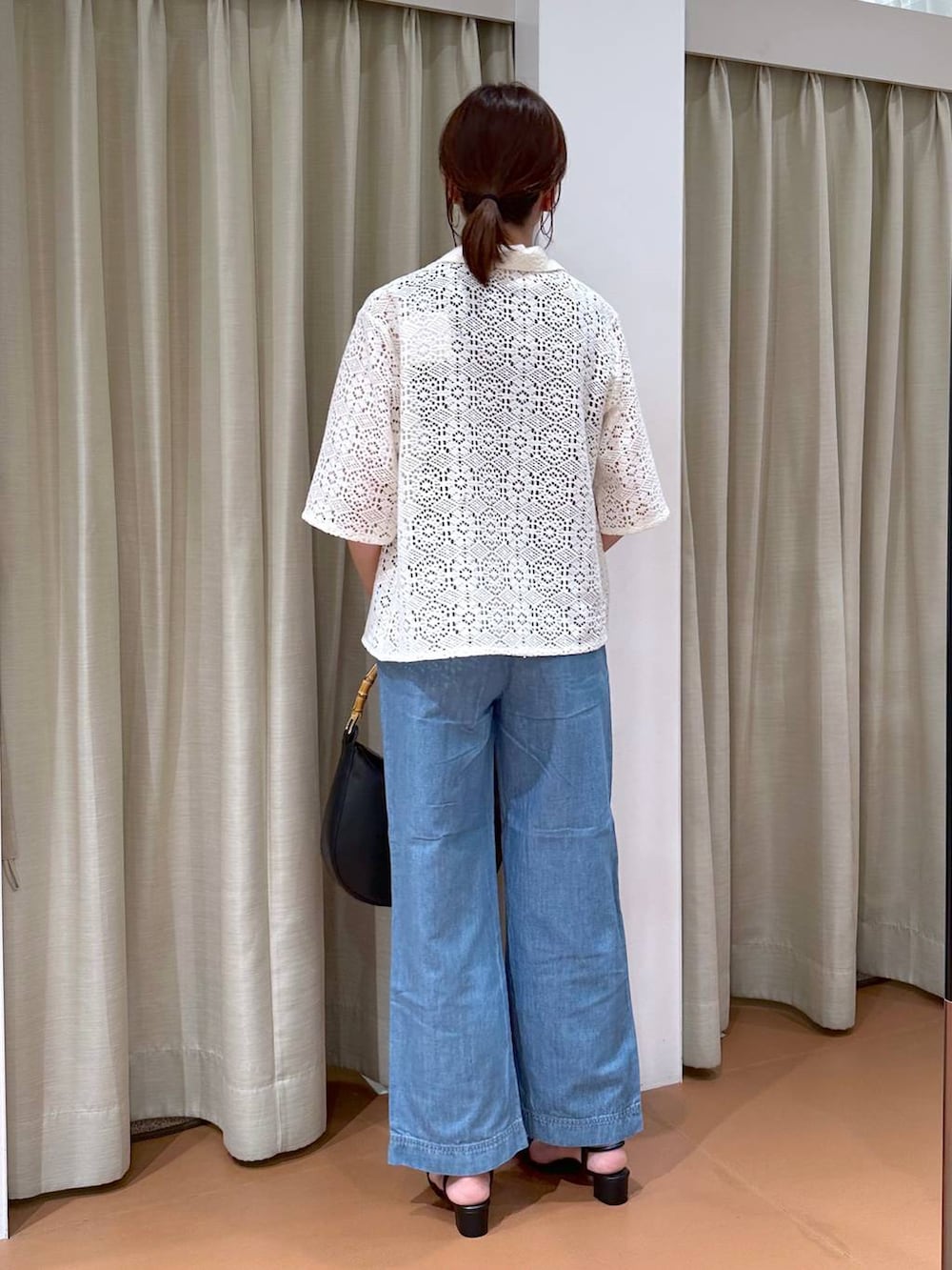 ブラック系のニット/セーター、ブルー系のデニムパンツ、ホワイト系のその他アウターを着用したレディースの夏コーディネートの4枚目の写真