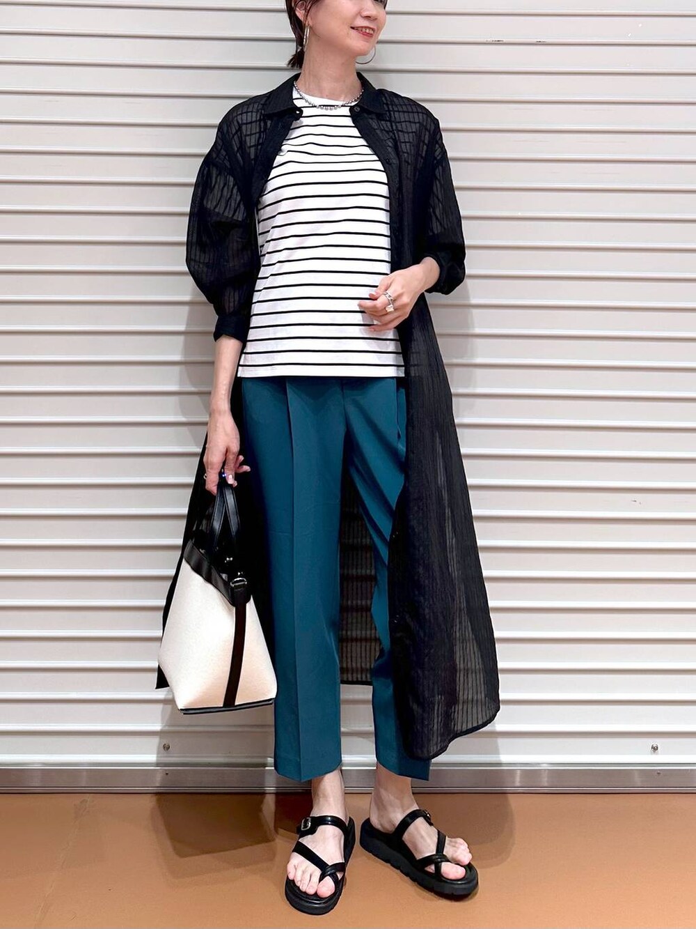 グリーン系のその他パンツ、ブラック系のサンダル、ブラック系のTシャツ/カットソーを着用したレディースの夏コーディネートの6枚目の写真