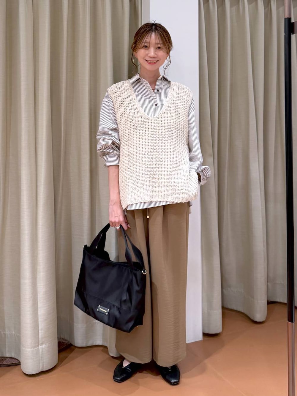 ブラック系のトートバッグ、ブラック系のパンプス、ブラウン系のシャツ/ブラウスを着用したレディースの春コーディネートの2枚目の写真