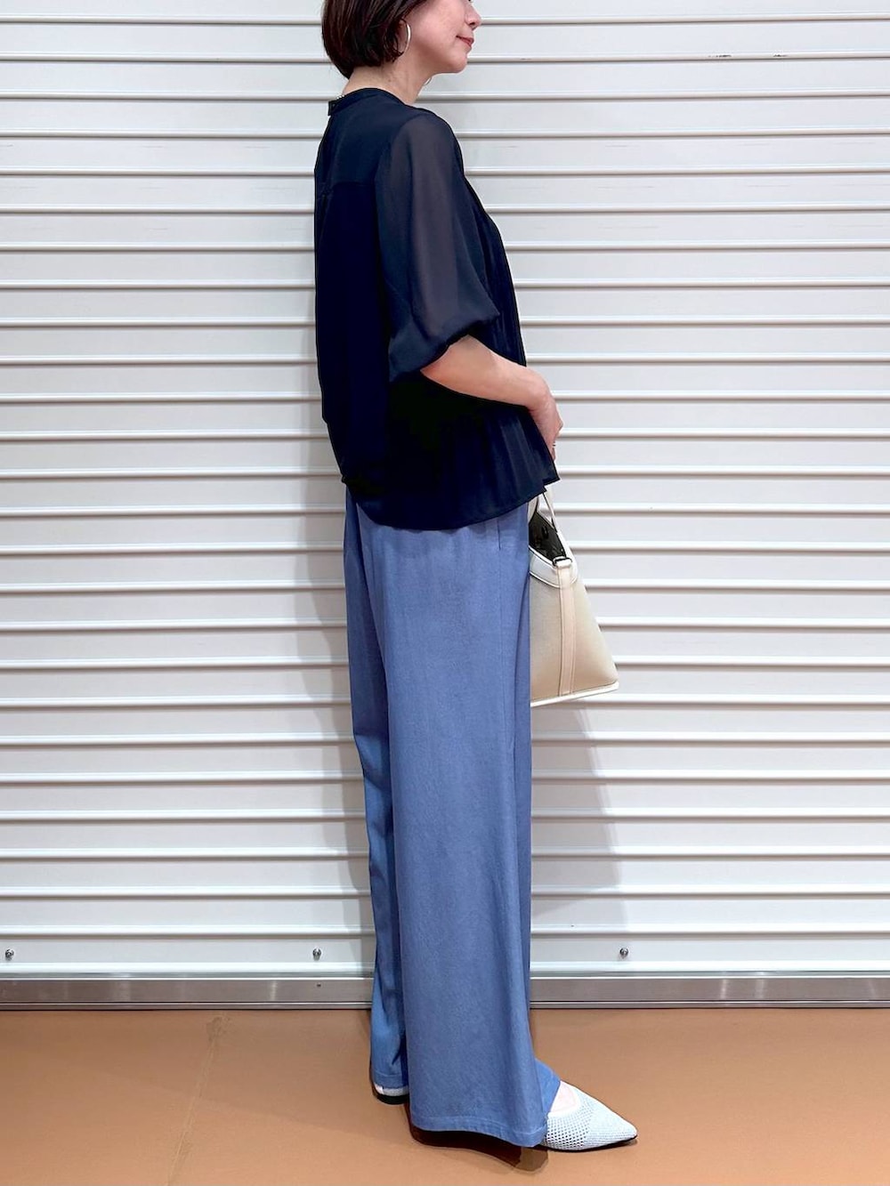 シルバー系のパンプス、ブルー系のシャツ/ブラウス、ブルー系のデニムパンツを着用したレディースの夏コーディネートの6枚目の写真