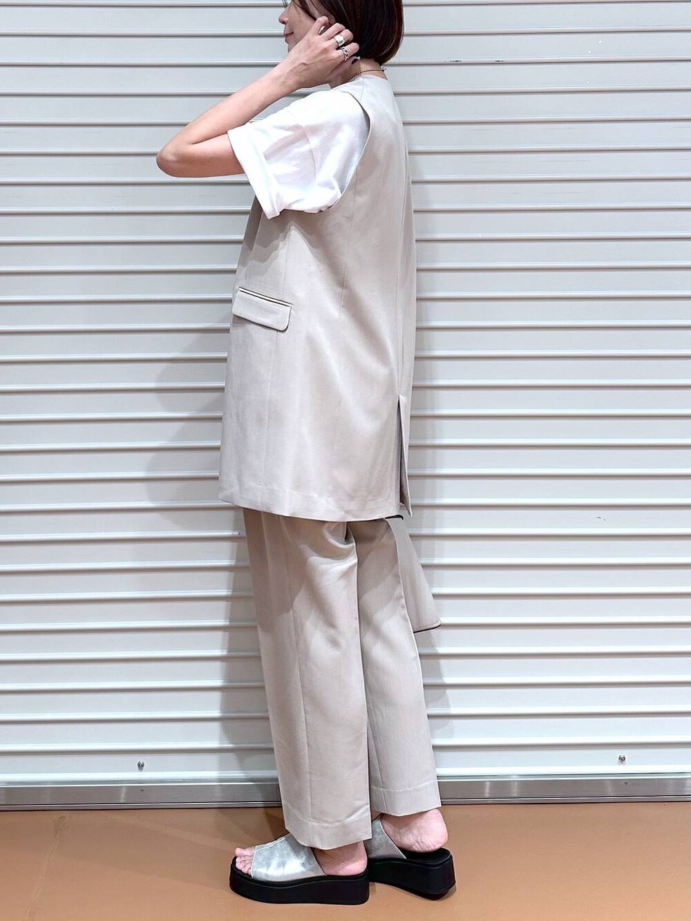 ベージュ系のベスト、シルバー系のサンダル、ホワイト系のTシャツ/カットソーを着用したレディースの夏コーディネートの6枚目の写真