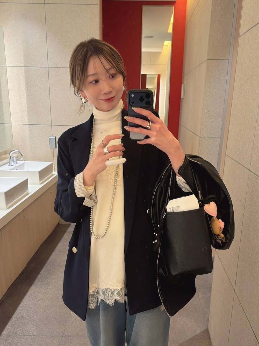 ホワイト系のTシャツ/カットソー、ホワイト系のパンプス、ブルー系のデニムパンツを着用したレディースの冬コーディネートの2枚目の写真