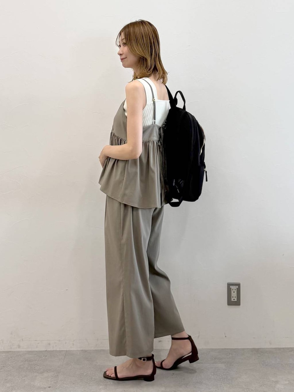 ブラック系のバックパック/リュック、グリーン系のその他パンツ、ブラウン系のサンダルを着用したレディースの秋コーディネートの3枚目の写真