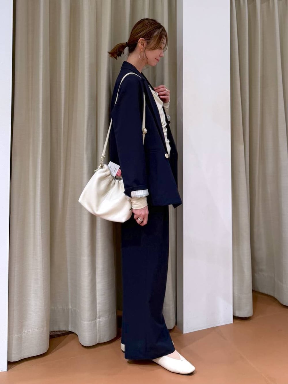 ホワイト系のハンドバッグ、ホワイト系のパンプス、ブルー系のその他パンツを着用したレディースの春コーディネートの5枚目の写真