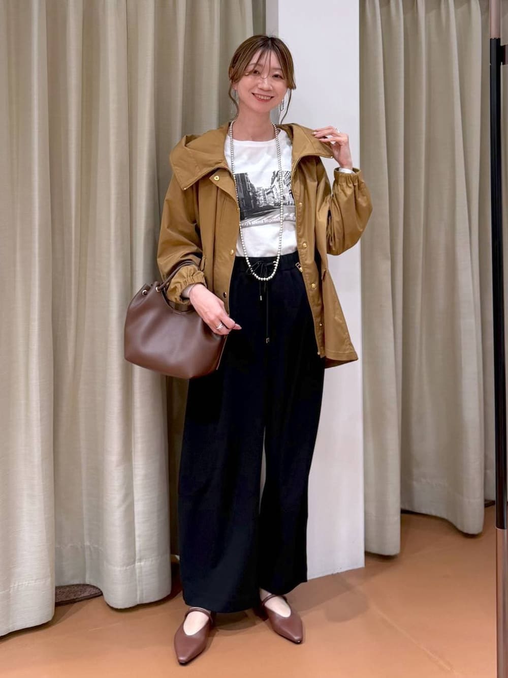 ブラック系のその他パンツ、ホワイト系のTシャツ/カットソー、イエロー系のマウンテンパーカーを着用したレディースの春コーディネートの2枚目の写真