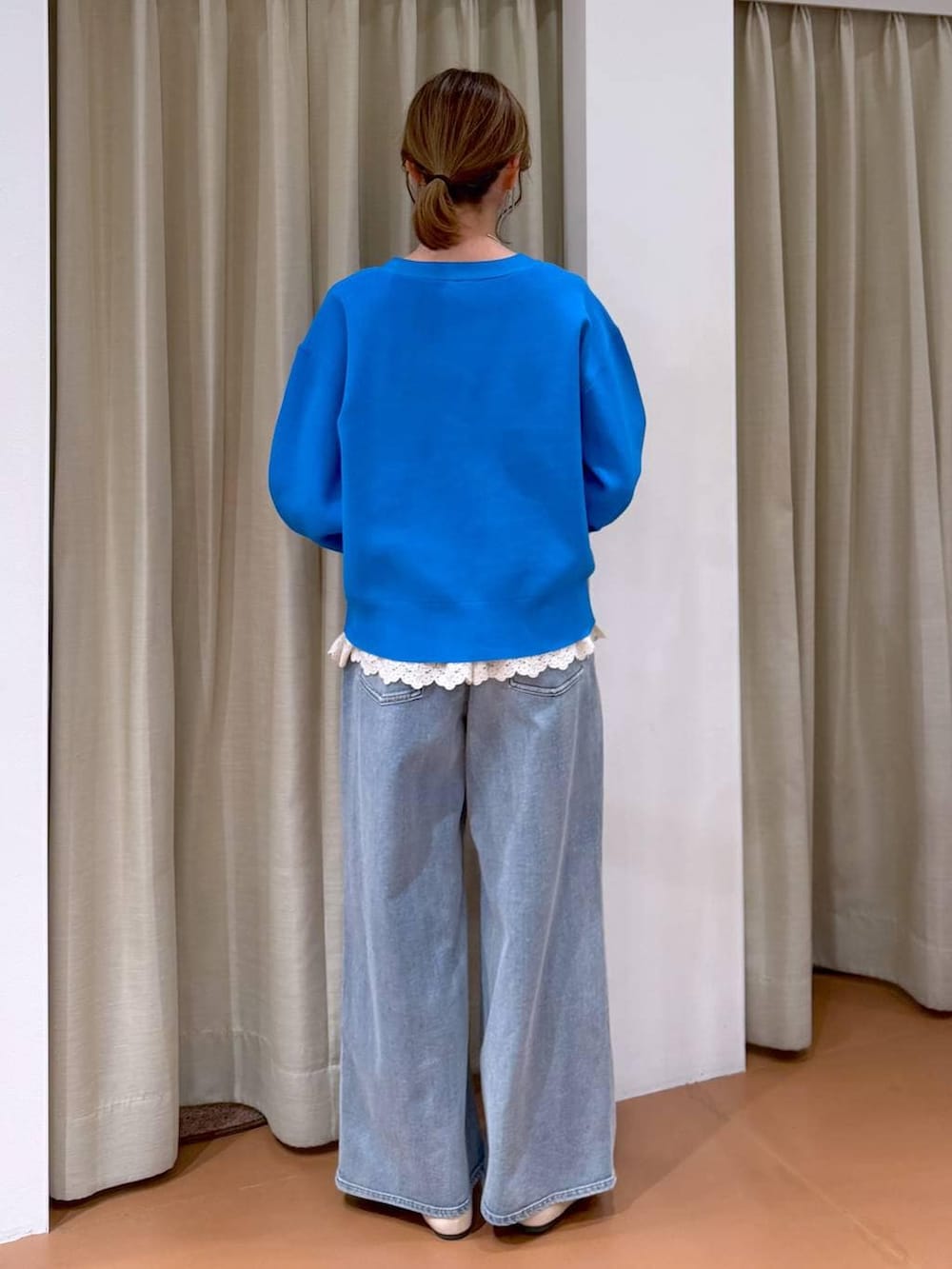 ホワイト系のパンプス、ホワイト系のタンクトップ、ブルー系のデニムパンツを着用したレディースの春コーディネートの4枚目の写真