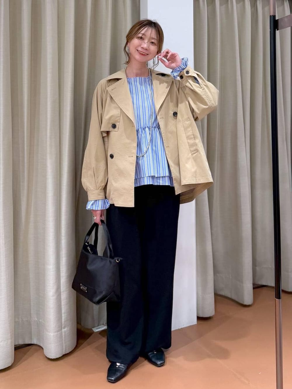 ブラック系のその他パンツ、ブラック系のパンプス、ブルー系のシャツ/ブラウスを着用したレディースの春コーディネートの2枚目の写真