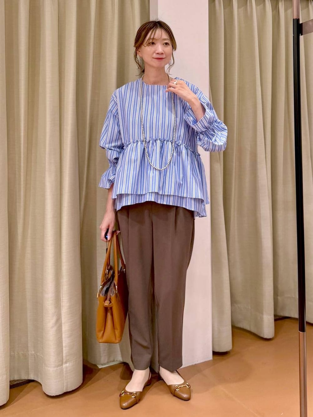 ブラウン系のその他パンツ、イエロー系のハンドバッグ、ブラウン系のパンプスを着用したレディースの春コーディネートの5枚目の写真