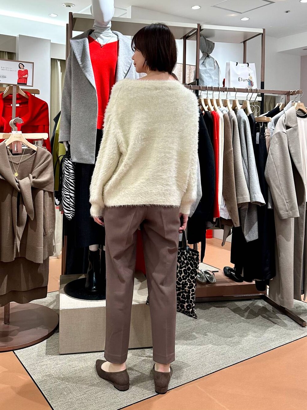 ブラウン系のその他パンツ、ブラウン系のパンプス、ホワイト系のニット/セーターを着用したレディースの冬コーディネートの4枚目の写真