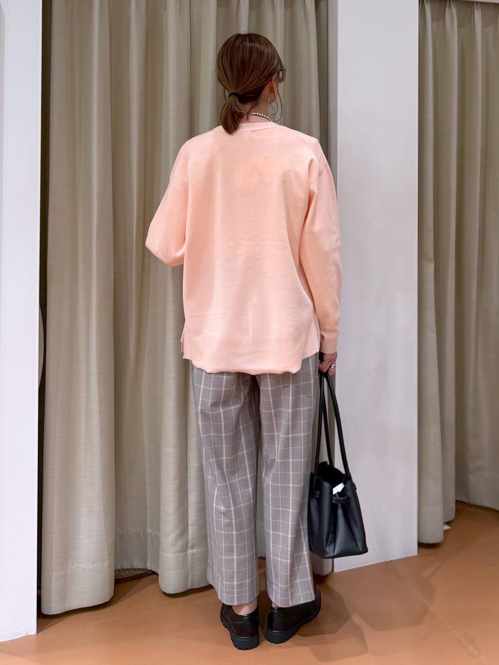 ピンク系のカーディガン/ボレロ、ブラック系のローファー、ブラック系のハンドバッグを着用したレディースの冬コーディネートの4枚目の写真