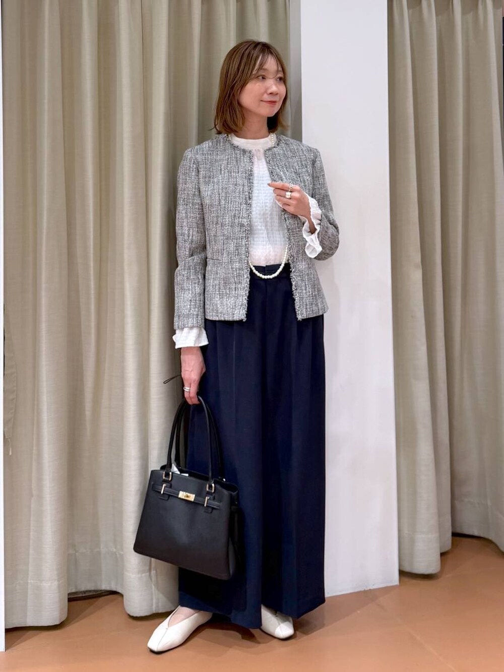 ホワイト系のパンプス、ホワイト系のシャツ/ブラウス、ブラック系のノーカラージャケットを着用したレディースの冬コーディネートの6枚目の写真