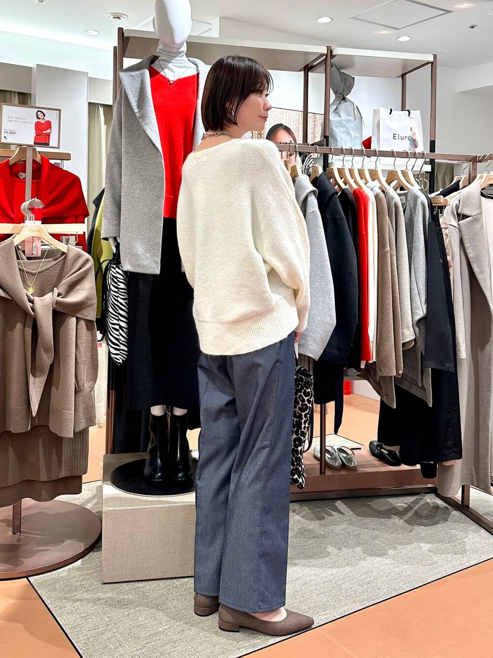ブルー系のデニムパンツ、ホワイト系のニット/セーター、ブラウン系のパンプスを着用したレディースの冬コーディネートの5枚目の写真