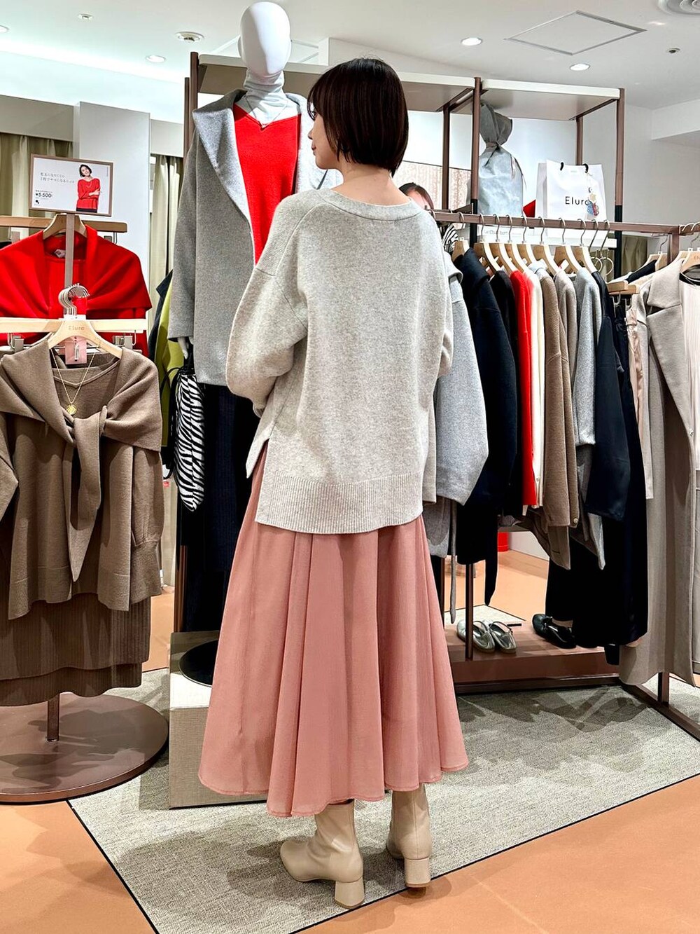 グレー系のニット/セーター、ベージュ系のブーツ、ピンク系のスカートを着用したレディースの冬コーディネートの4枚目の写真