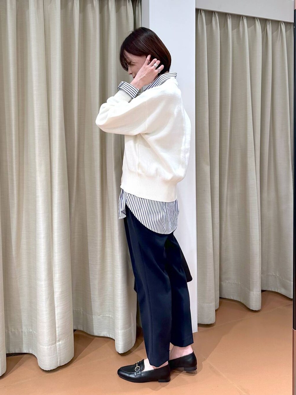 ブラック系のローファー、ブルー系のスーツパンツ、ブラック系のハンドバッグを着用したレディースの冬コーディネートの6枚目の写真