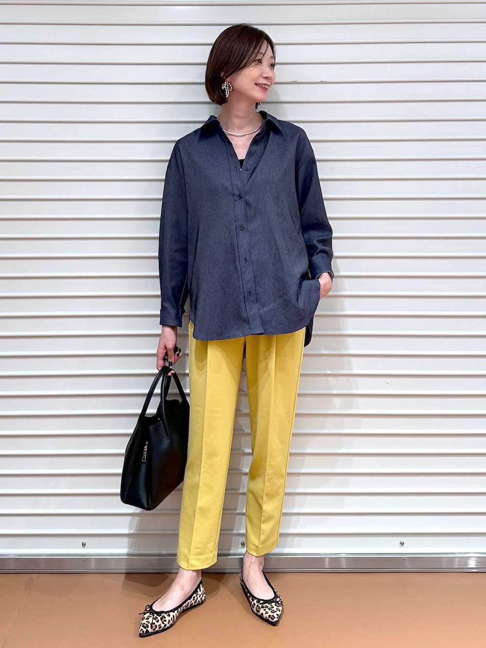 イエロー系のその他パンツ、ブラック系のハンドバッグ、ブラウン系のパンプスを着用したレディースの夏コーディネートの2枚目の写真